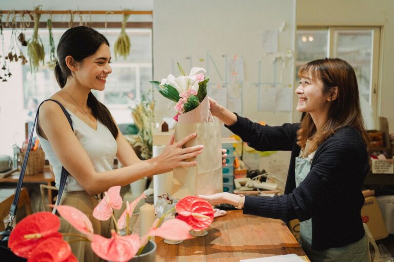 A florist handing a bouquet to a customer
